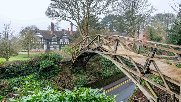 A view looking towards Wightwick Manor from the Bridge Garden. The newly restored Mathematical Bridge can be seen in the foreground, with the Manor in the background.